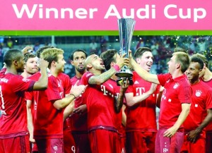 Bayern Munich's Chilean midfielder Arturo Vidal and Bayern Munich's defender Philipp Lahm hold up the trophy after the Audi Cup final football match Real Madrid vs FC Bayern Munich in Munich, southern Germany, on August 5, 2015. Bayern Munich won the match 1-0. AFP PHOTO / CHRISTOF STACHE