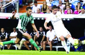 epa04904643 Real Madrid's Colombian midfielder James Rodriguez (R) in action against Real Betis' midfielder Xavi Torres (L) during their Spanish Primera Division soccer match at Santiago Bernabeu stadium in Madrid, Spain, 29 August 2015.  EPA/ZIPI