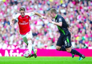 Arsenal's Mesut zil, left, fights for the ball with Stoke City's Glenn Whelan, during their English Premier League soccer match between Arsenal and Stoke City, at Emirates Stadium, in London, Saturday, Sept. 12, 2015. (AP Photo/Bogdan Maran)