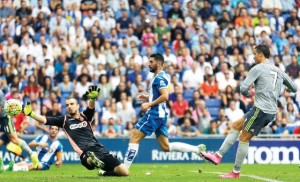 Real Madrid's Cristiano Ronaldo, right, kicks the ball to score against Espanyol's goalkeeper Pau Lopez, during a Spanish La Liga soccer match  at Cornella-El Prat stadium in Cornella Llobregat, Spain, Saturday, Sept. 12, 2015. (AP Photo/Manu Fernandez)